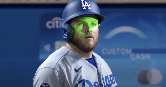 a dodgers player with a laser shined in his face