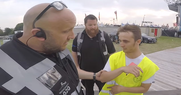 security guards confronting a man in a yellow safety vest