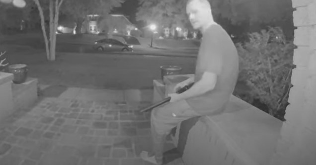 black and white video from a nest camera with a man holding a shotgun