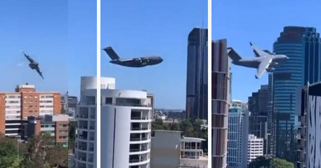 Royal Australian Air Force cargo jet flies very close to Brisbane skyscrapers.