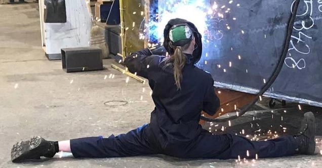 a woman doing a split while welding