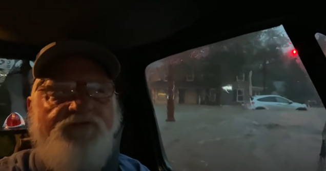 old man in a truck stuck in flood waters