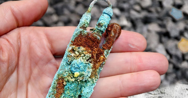 a man holding an old rusted and petina ww2 era lighter