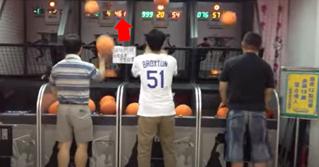 a guy playing a basketball arcade game