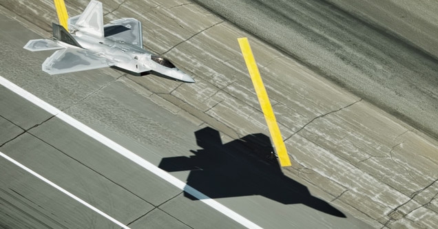 an f22 raptor flying low above the ground