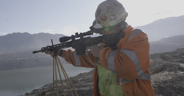 a man shooting at birds to keep them off toxic waste water