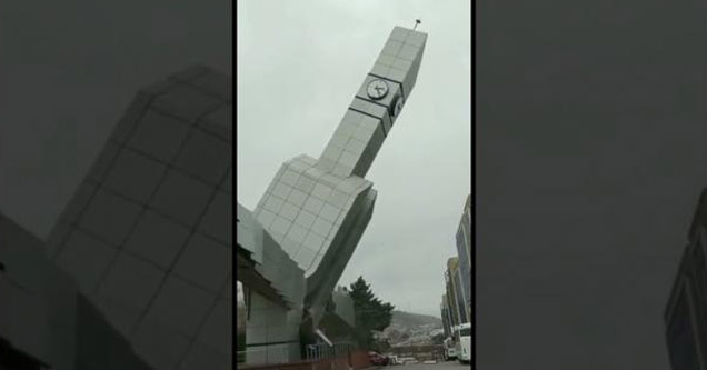 a clock tower collapsing in hurricane winds