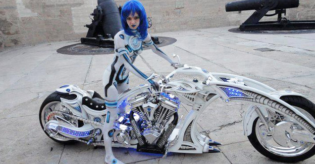 a girl in white suit and blue hair on a futuristic looking chopper