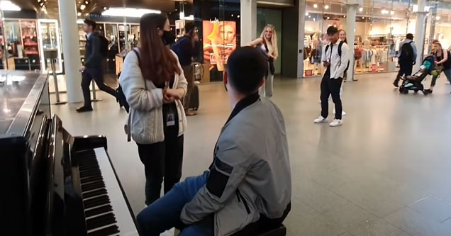 a woman playing a public in piano