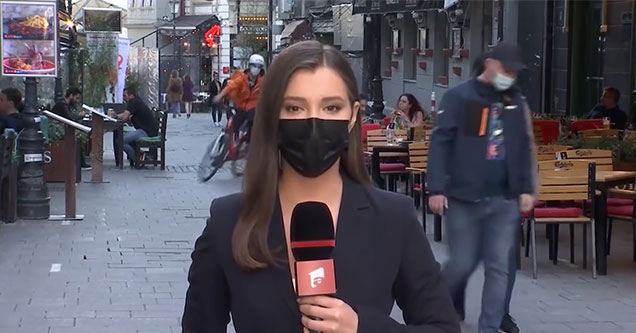 news anchor standing on the street -  bike messenger crashes behind her