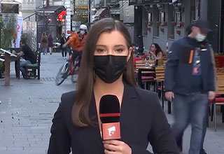 news anchor standing on the street -  bike messenger crashes behind her