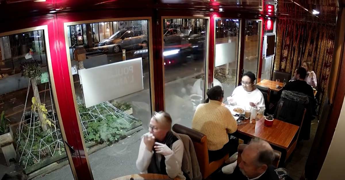 diners watching a car fly by at high speeds