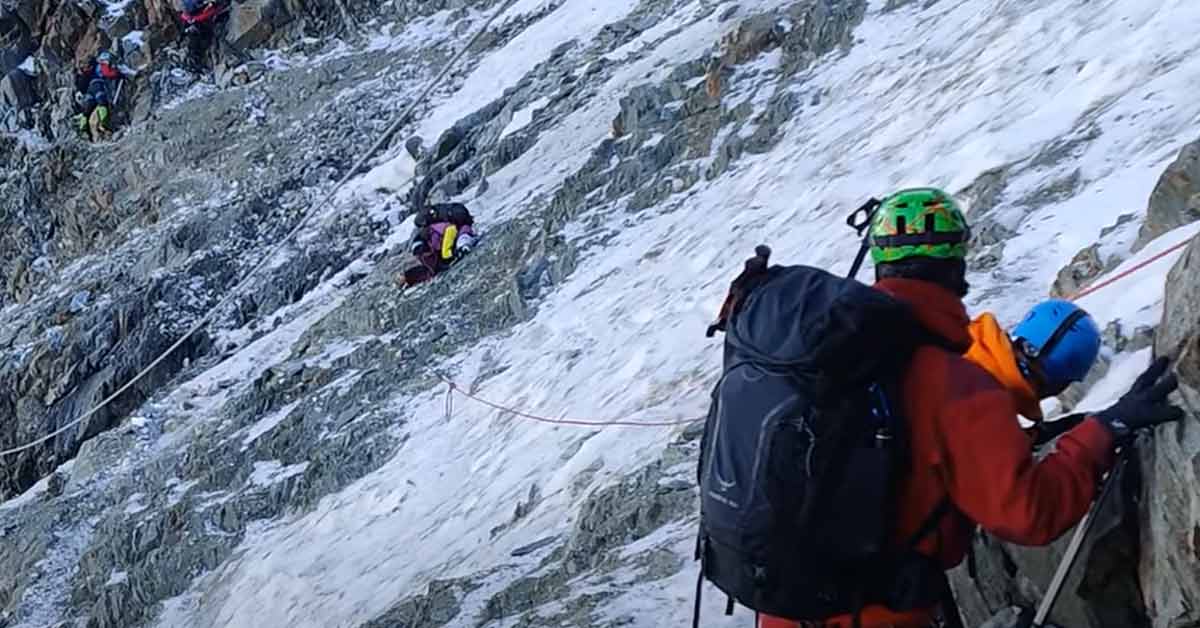 a hiker hunkering down as rocks fall all around him