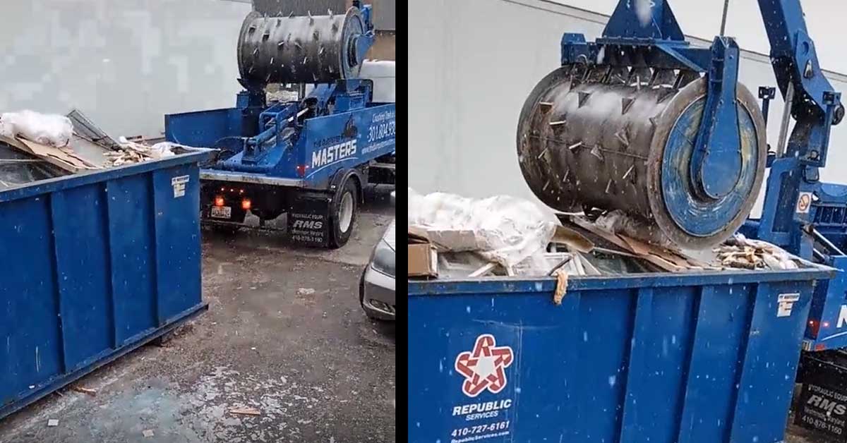 a mobile industrial shredder grinding up a dumpster