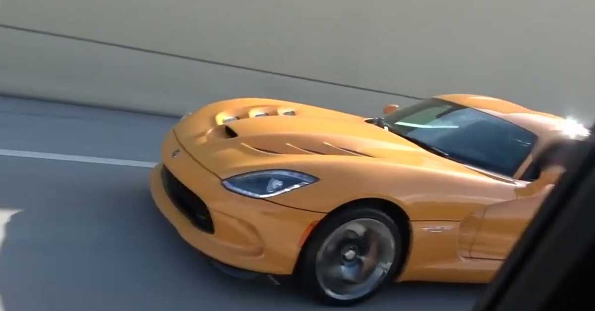 a yellow dodge viper racing a truck