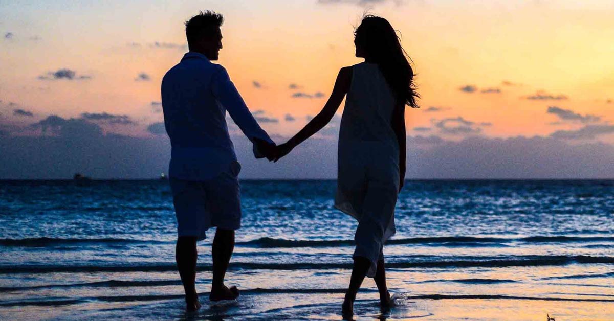 couple holding hands on the beach