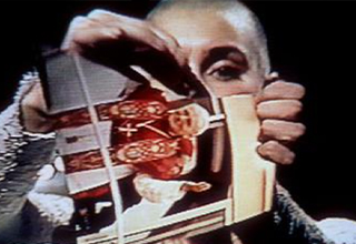 <p>Of all the performances that defined the late Sinéad O'Connor's storied career, none made quite as large of an impact as her fateful 1992 appearance on <em>Saturday Night Live</em>, where she ripped a photo of Pope John Paul II in half before an audience of shocked fans.&nbsp;</p><p><br>From O'Connor's protesting past to the legacy of her controversial act, here are 12 photos that tell the story of her infamous <em>SNL</em> moment.&nbsp;</p>