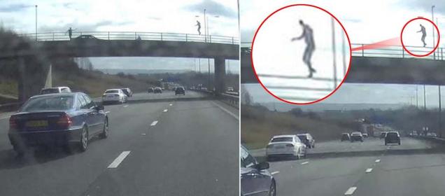 Terrifying moment man 'walks balance beam' on railings above busy motorway