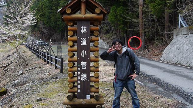 man posing next to sign in japanese