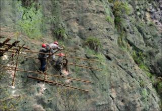Check out these photos of brave but crazy construction workers building a road on the side of a cliff. These guys must have 50lb balls