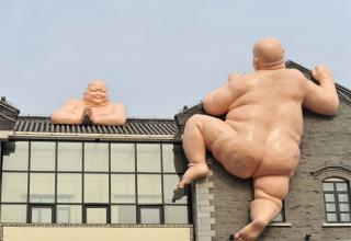 A Chinese restaurant has removed two naked 50ft statues of Buddha from its roof after Buddhist followers were so angered by their religions leader being used as an advert that they began protesting outside the eatery, demanding the figures be taken down.