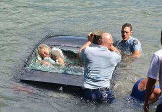 Police officers rescue a woman trapped her in car as it sinks into what would have been her watery grave.